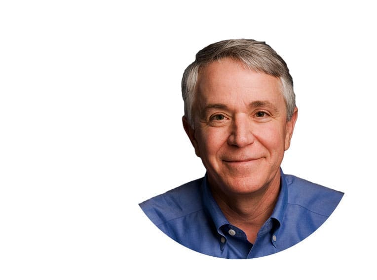 Smiling older man in a blue shirt.