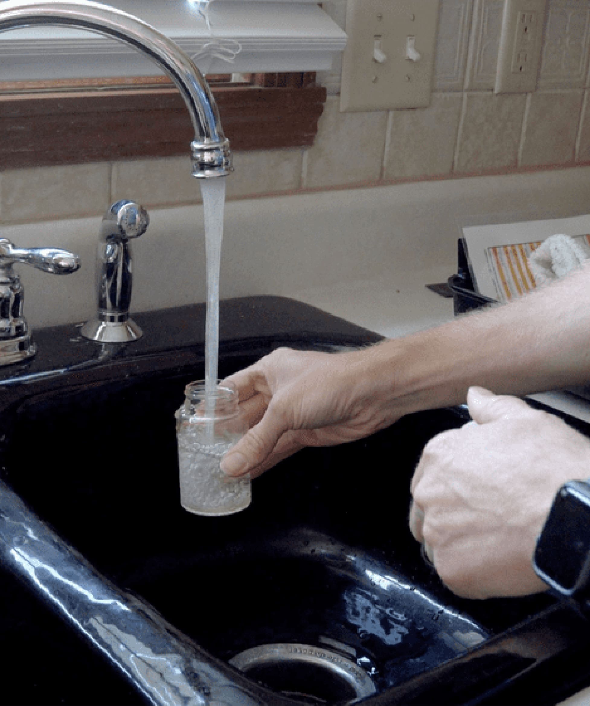 Collecting a water sample from a kitchen faucet for a free home water analysis.