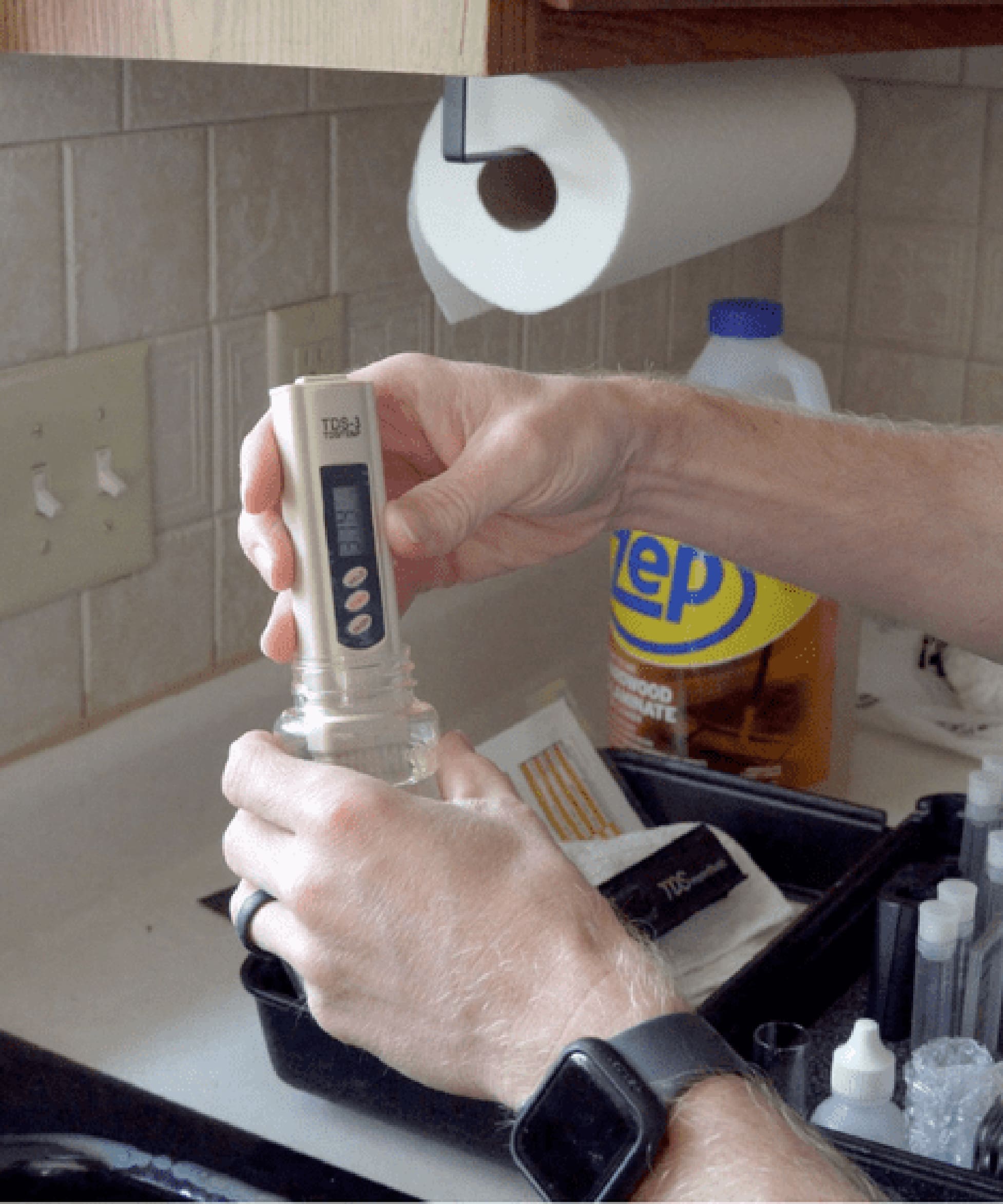 C and J Water technician using a digital water quality meter during a free in-home water analysis.